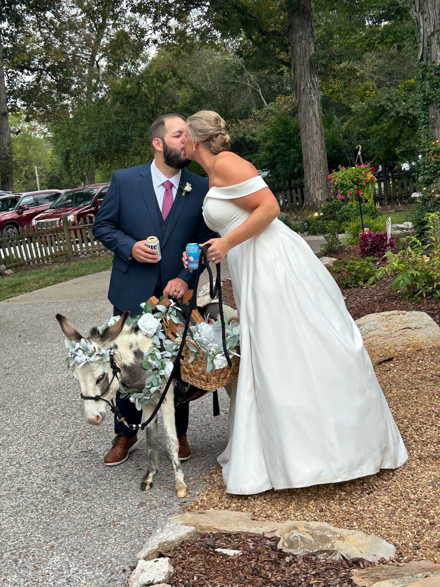 Newlyweds kissing beside Peaches carrying drinks